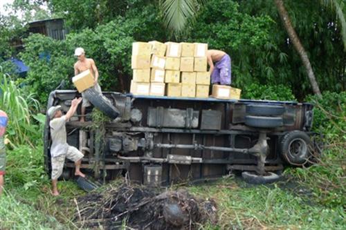 Xe tải lật xuống ao, 2 tấn sách giáo khoa bị ướt